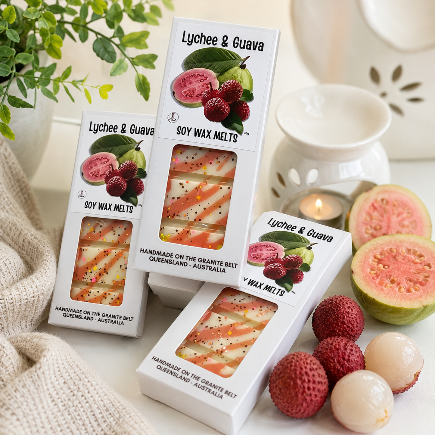 Lychee & Guava Soy Wax Melts by Lee's Little Luxuries displayed in a luxury home setting with a ceramic wax burner, fresh lychees and guava, handmade 45g soy wax melts from the Granite Belt, Queensland, Australia.
