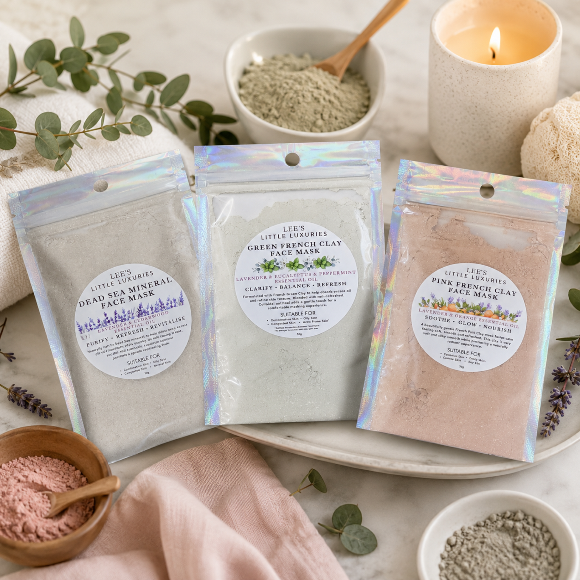 Assorted Clay Face Masks displayed in a luxury spa setting with pink clay, lavender flowers, a candle and soft towels.