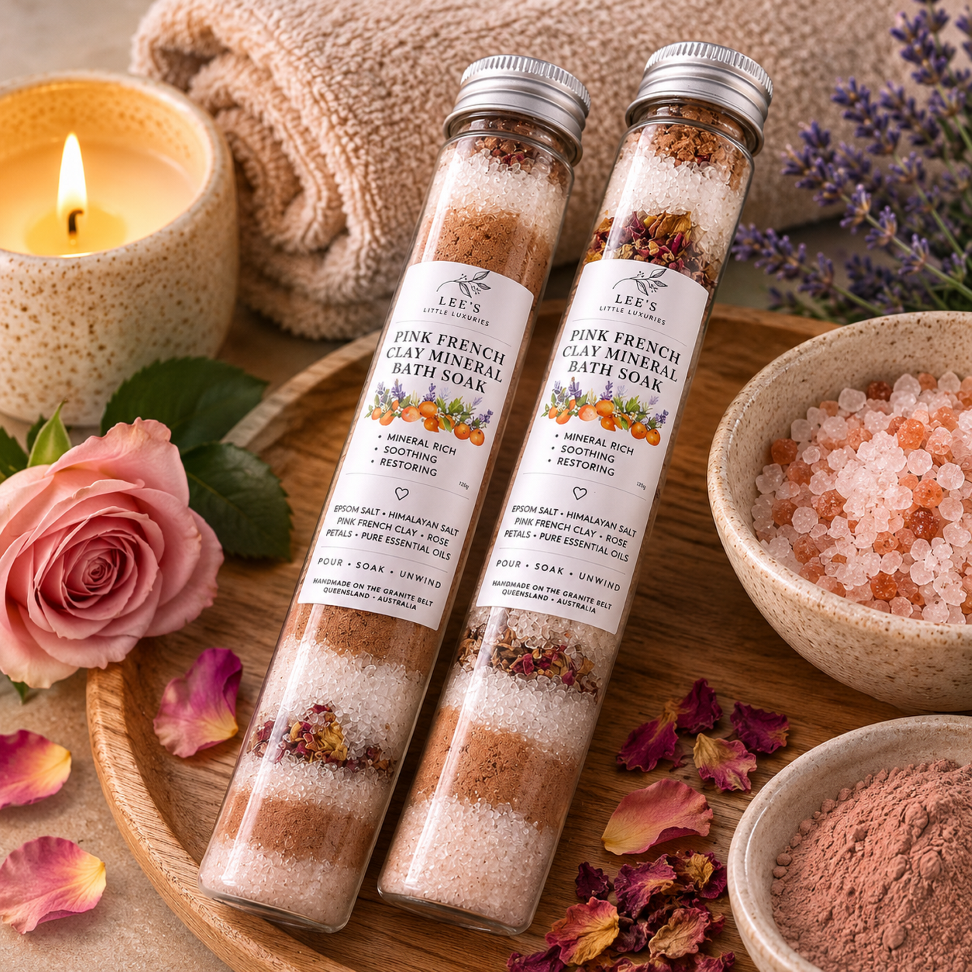 Pink French Clay Mineral Bath Soak displayed in a luxury spa setting with soft towels, candles, rose petals and botanical accents.