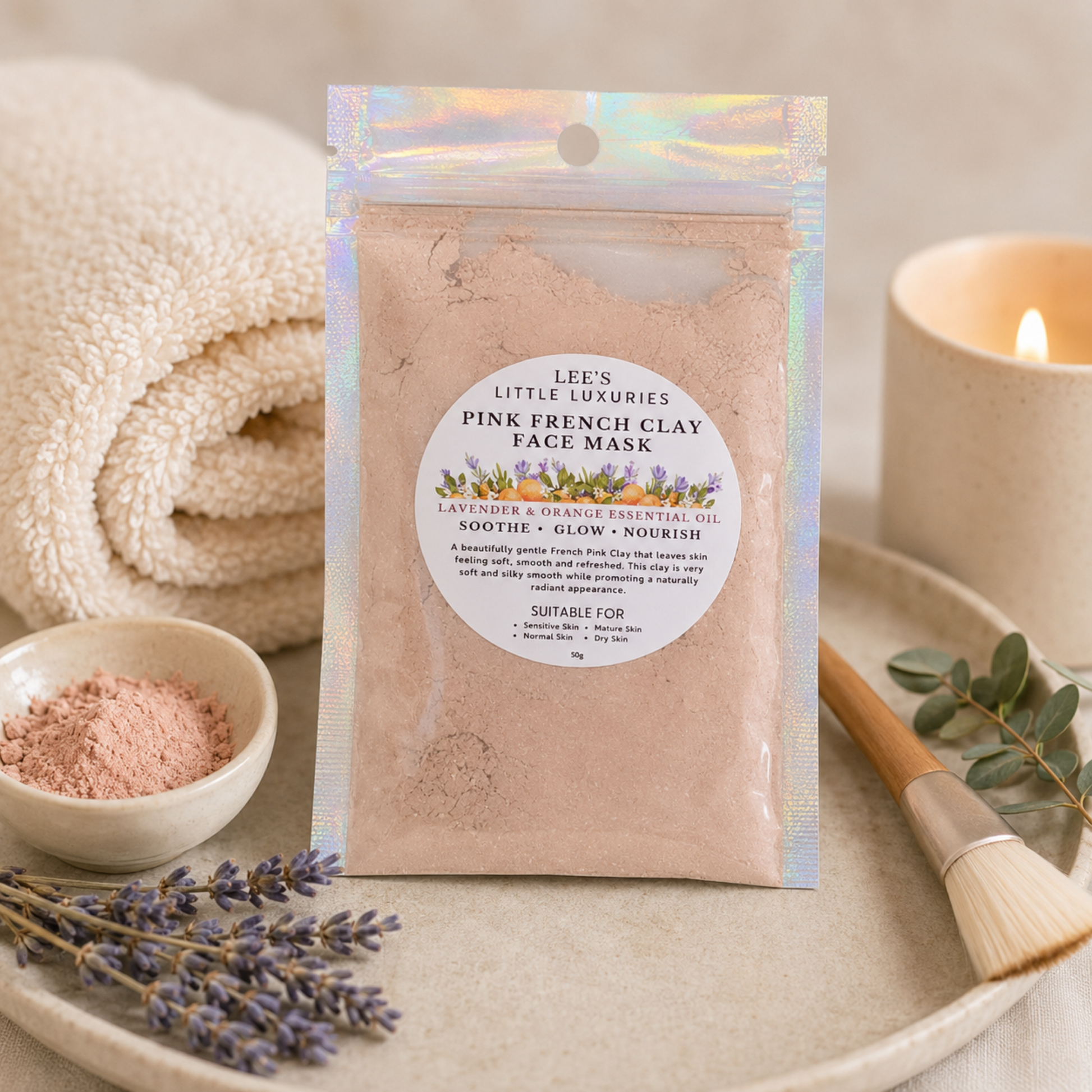 Pink French Clay Face Mask displayed in a luxury spa setting with pink clay, lavender flowers, a candle and soft towels.